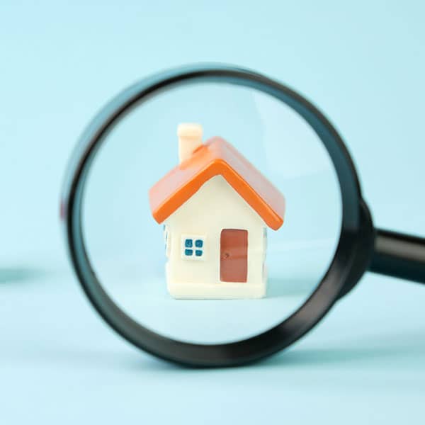 Magnifying glass looking at house